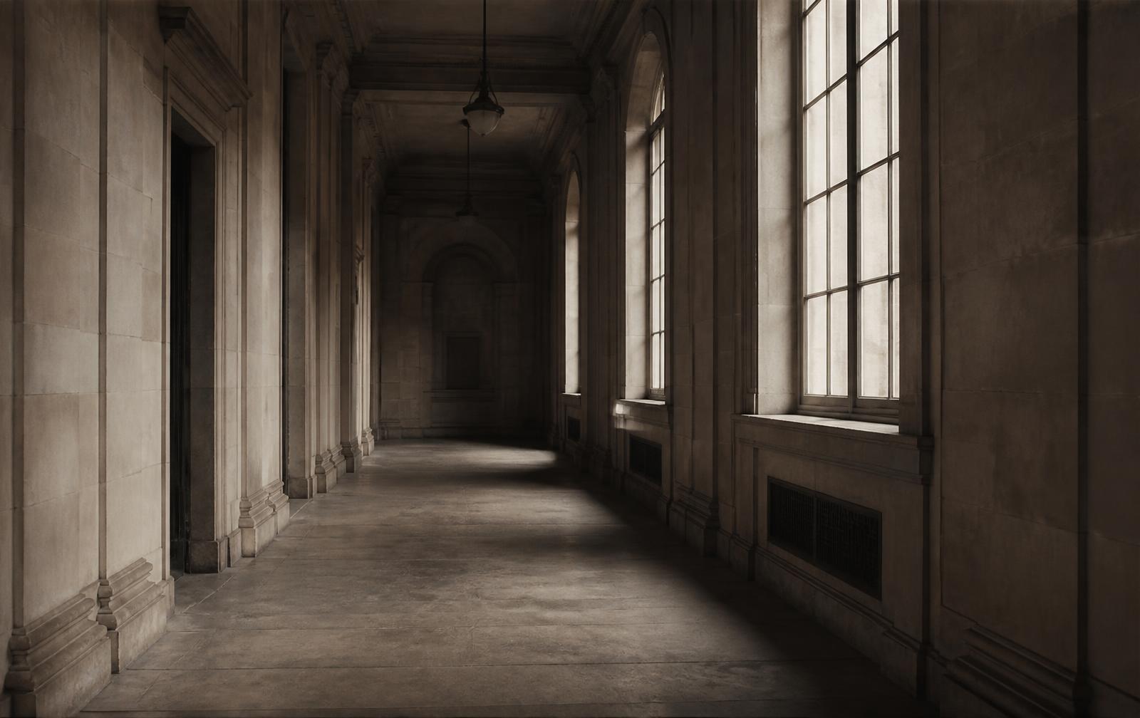 An empty institutional corridor lit by tall windows